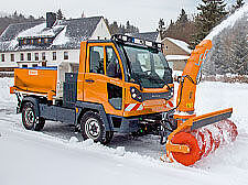 Kommunalfahrzeug befreit im Winter ein Wohngebiet von Schnee.