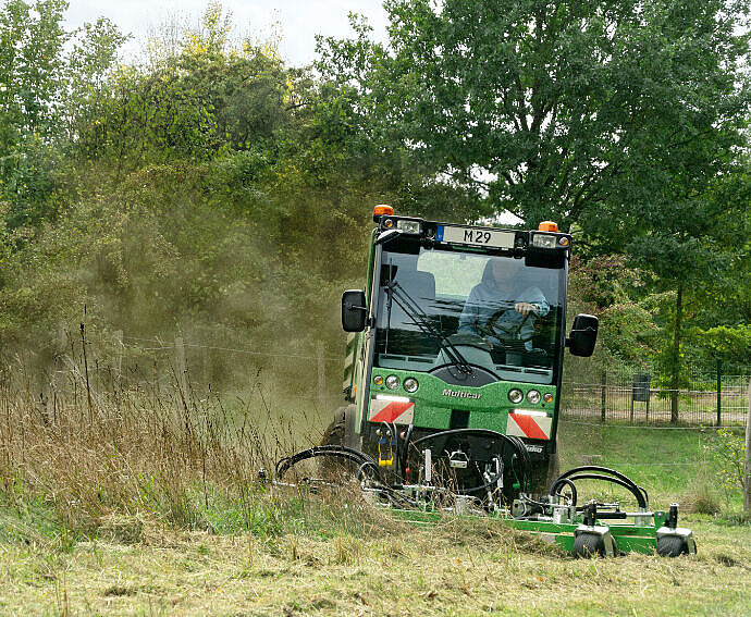 Kommunalfahrzeug bei der Grünpflege, Unkrautbekämpfung und Bewässerung einer Wiese.